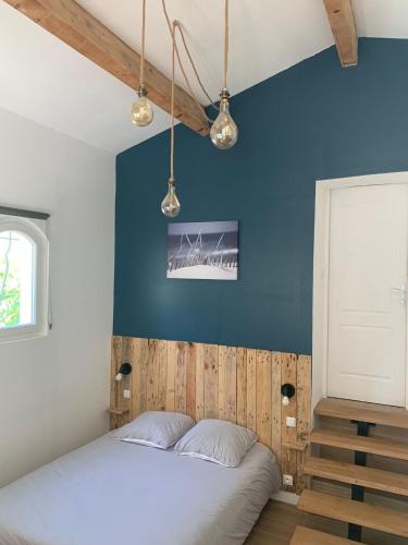une chambre avec un lit avec un mur bleu dans l'établissement Guest house proche Aix en Provence, à Simiane-Collongue