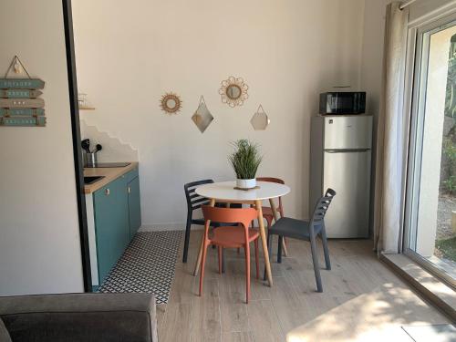 cocina con mesa, sillas y nevera en Guest house proche Aix en Provence, en Simiane-Collongue