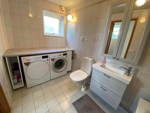 a bathroom with a washing machine and a sink at Beautiful view at unique farm in Höör