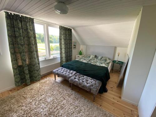 a bedroom with a bed and a large window at Beautiful view at unique farm in Höör