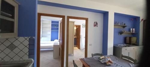 a room with blue walls and a room with a table at Casa vacanze Lipari da Sergio spiaggia sotto casa in Lipari