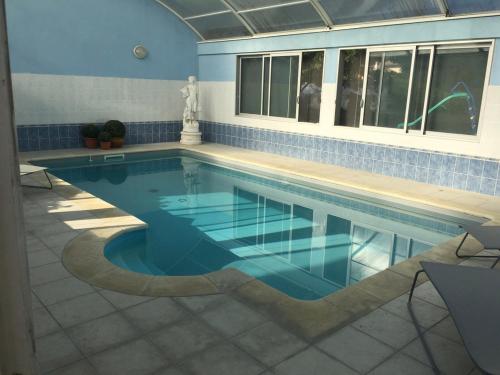 - une grande piscine revêtue de carrelage bleu dans l'établissement Le Clos Du Jardin, à Beynost