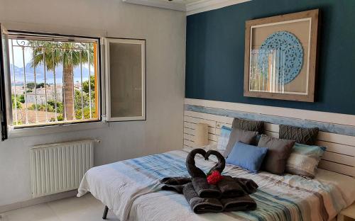 sypialnia z łóżkiem z wypchanym zwierzakiem w obiekcie Villa Las Palmeras with roof terrace w Altei