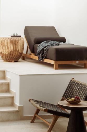 a bed sitting on top of a table with a chair at Asty Mykonos Hotel & Spa - World of One Hotel Group in Mýkonos City