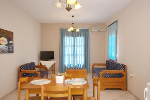 een woonkamer met een tafel en stoelen bij Kavos Apartments in Patitiri