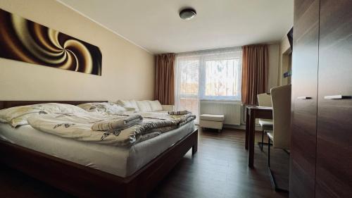 um quarto com uma cama, uma secretária e uma janela em Ubytování Lednice em Lednice