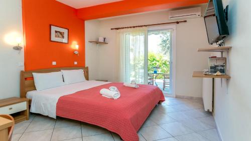 a bedroom with a bed with a red wall at Amversa's House in Potos