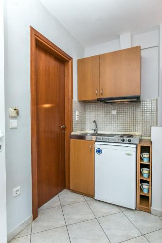 a kitchen with a white dishwasher and a wooden door at Amversa's House in Potos