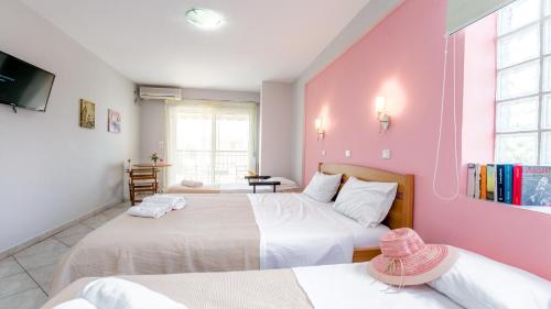 a bedroom with two beds and a pink wall at Amversa's House in Potos