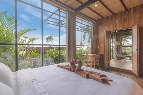 a large bed in a room with a large window at Kayukopi in Munduk