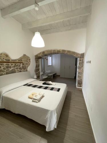 ein Schlafzimmer mit einem großen Bett und einer Steinmauer in der Unterkunft APPARTAMENTO S.ANTIOCO in SantʼAntìoco