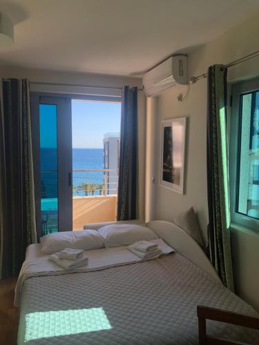 a bedroom with a bed with a view of the ocean at Apartments Rafailović Ljubo in Rafailovici