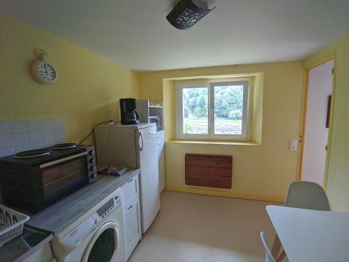 kuchnia z białą lodówką i oknem w obiekcie Appartement entier, vue sur rivière & cathédrale. w mieście Plouguiel