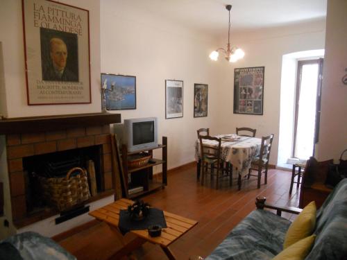 a living room with a fireplace and a dining room at Casale di montagna in Cansano