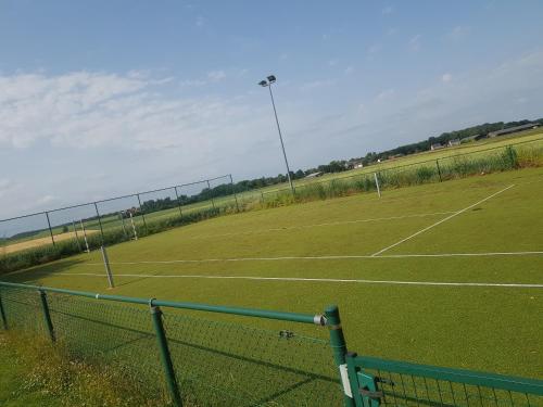 a tennis court with two tennis courts at La Clé des Champs in Jodoigne