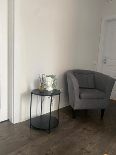 a living room with a chair and a table with a vase at Kamurke - Guest House in Šiauliai