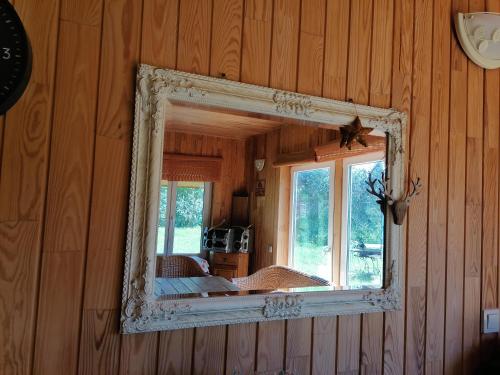 a mirror on the side of a wooden wall at Elniaragio Guolis 