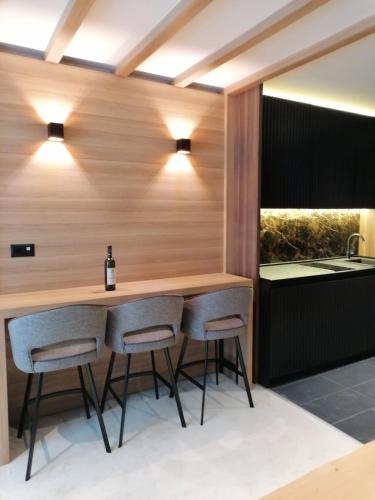 a kitchen with a bar with two stools at Kopaonik011 Konaci&WoodSide Apartments in Kopaonik