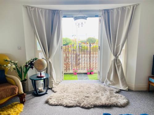 a living room with a large window with a white rug at Sea House in Hastings