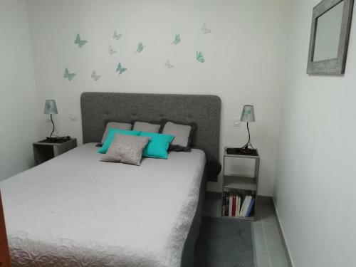 - une chambre avec un lit doté d'oreillers bleus et gris dans l'établissement au coeur des coteaux du Layon, à Le Champ-sur-Layon