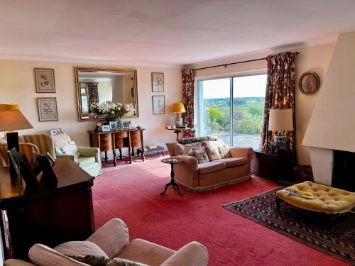 a living room filled with furniture and a large window at Whitehouse in Uplawmoor