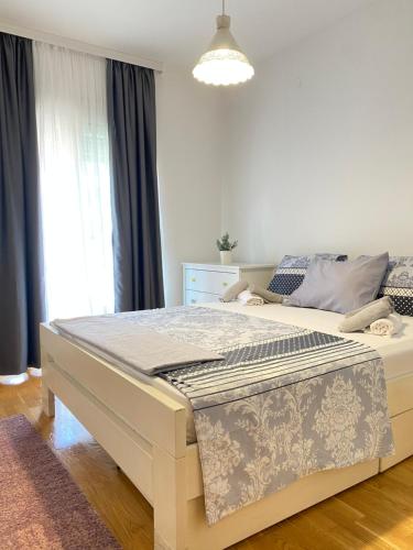 a white bed in a bedroom with a window at Apartman Vesna City 2. PG in Podgorica
