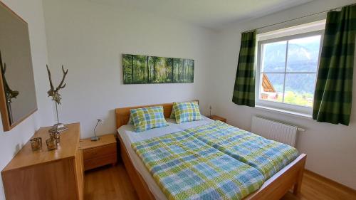 sypialnia z łóżkiem i oknem w obiekcie Appartement Zirkl / Haus Gloria w mieście Haus im Ennstal