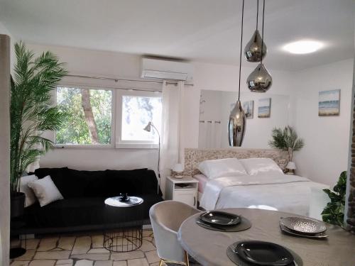 a living room with a bed and a table at Relax tiny villas 40 meters of the beach in Korčula