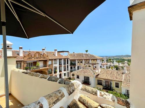 desde el balcón de un edificio con sombrilla en Outstanding VIEWS @ Puebla Aida - Roof terrace with Sea, Mountain and Golf view by Solrentspain, en Mijas