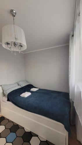 a bedroom with a bed with a blue blanket at Lovely flat in heart of Wroclaw in Wrocław