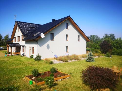 een wit huis met zonnepanelen op het dak bij Pensjonat Ślepowron in Międzywodzie