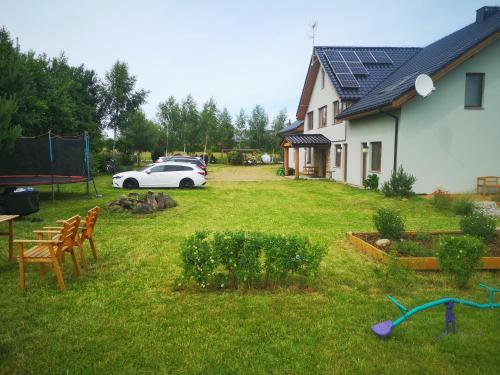 een witte auto geparkeerd in een tuin naast een huis bij Pensjonat Ślepowron in Międzywodzie