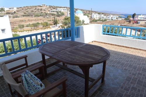 a wooden table and chairs on a balcony at Taxiarchis Studios in Áyios Yeóryios