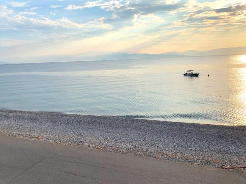 a boat in the water on a beach at A Place of Philoxenia in Aíyira