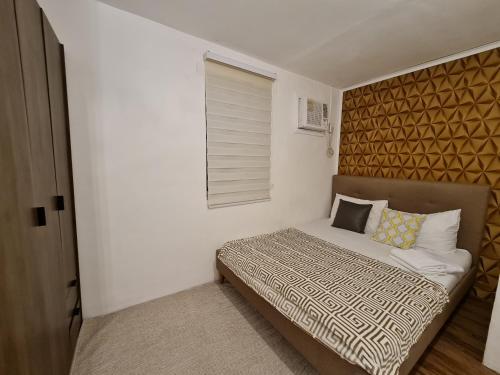 ein kleines Schlafzimmer mit einem Bett und einem Fenster in der Unterkunft MC RESIDENCES in General Santos