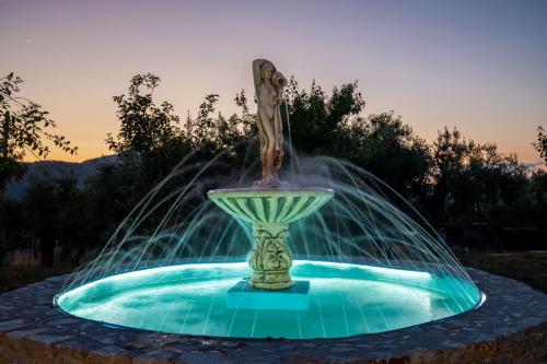 a statue of a woman sitting in a fountain at Giasemi Apartments in Skopelos Town