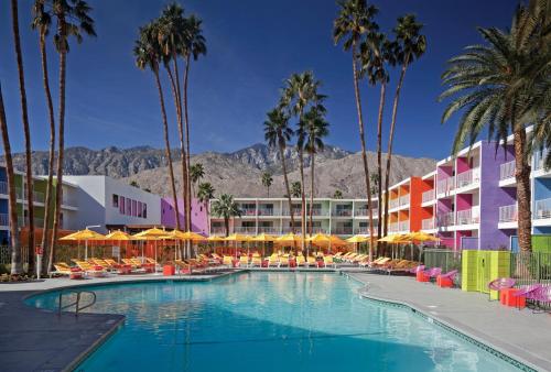 um hotel com uma piscina com palmeiras e edifícios em The Saguaro Palm Springs em Palm Springs