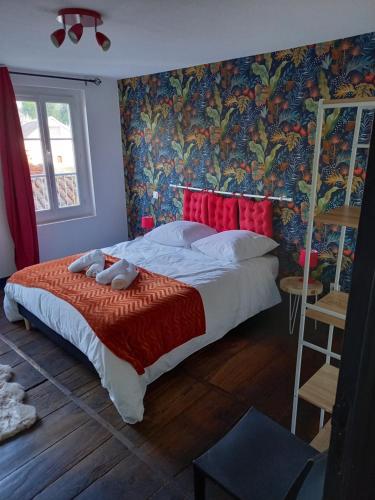 una camera da letto con un grande letto e carta da parati colorata di Appartement 3 pièces centre ancien de tulle a Tulle