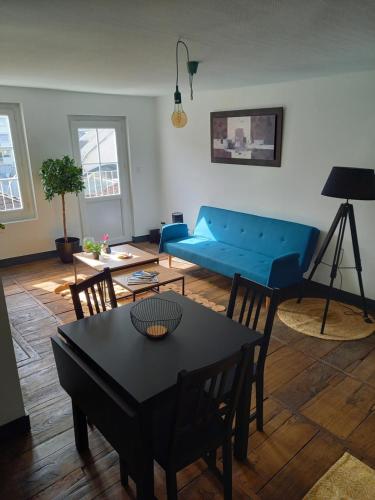 a living room with a blue couch and a table at Appartement 3 pièces centre ancien de tulle in Tulle