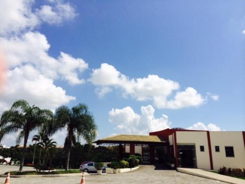 a building with a car parked in a parking lot at Hotel BHS in Linhares