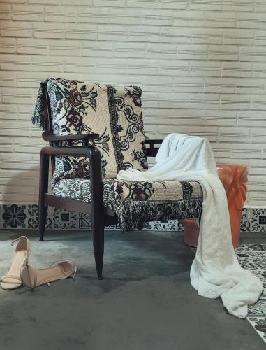 a couch with a blanket on it next to some shoes at Mekong Pottery Homestay, Green-Friendly & Boat Tour in Vĩnh Long