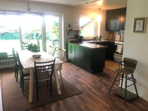 une cuisine avec une table et des chaises et une cuisine avec un comptoir dans l'établissement Gatehouse at unique farm, neighbour to yaks & emus, à Höör