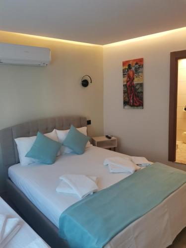 1 dormitorio con 1 cama grande con almohadas azules en SIĞACIK SEN KONUK EVİ en Seferihisar