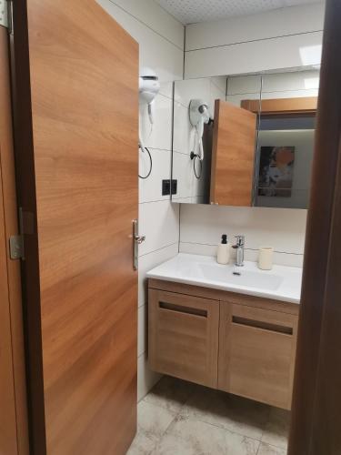 a bathroom with a sink and a wooden door at SIĞACIK SEN KONUK EVİ in Seferihisar
