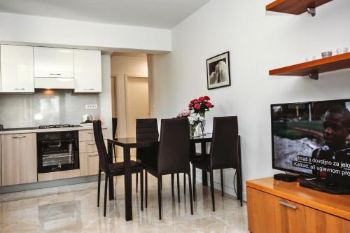 a kitchen and dining room with a table and chairs at Ana in Preko