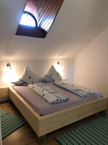 Bett in einem Schlafzimmer mit Dachfenster in der Unterkunft Gut Strackholt FeWo Seemannsgarn in Großefehn 