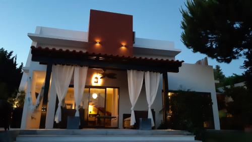a white house with white curtains in front of it at VILLA DA FONTE - BY MECO in Alfarim
