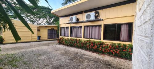 a yellow building with flowers in front of it at Chalet San Juanillo in San Juanillo
