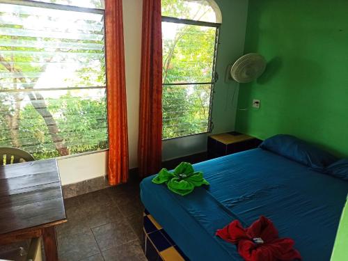 a bedroom with a blue bed and a window at Boca Brava Lodge in Boca Chica