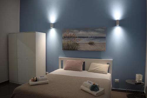 a bedroom with a bed and a painting on the wall at I Venti in Brucoli